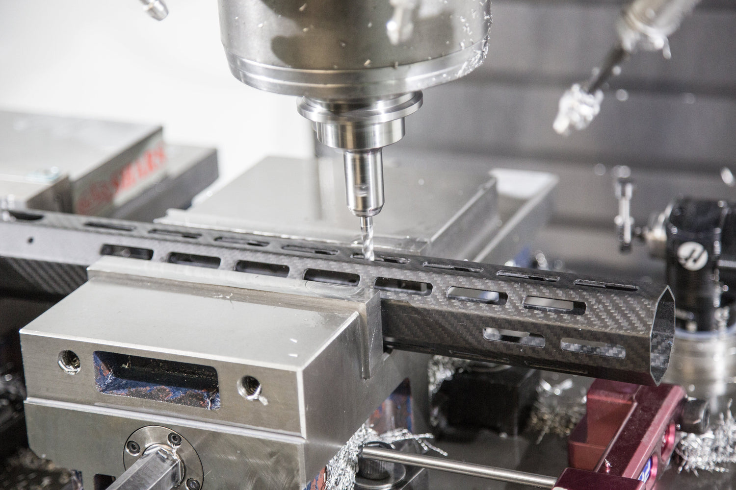 Precision milling machine working on carbon fiber component in a modern workshop