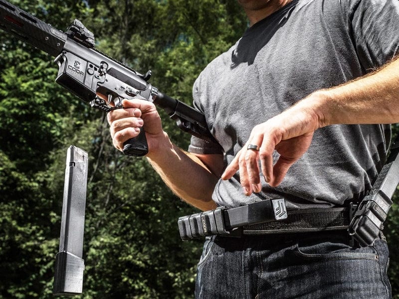 Man handling a firearm in a natural outdoor setting, showcasing safety and preparedness